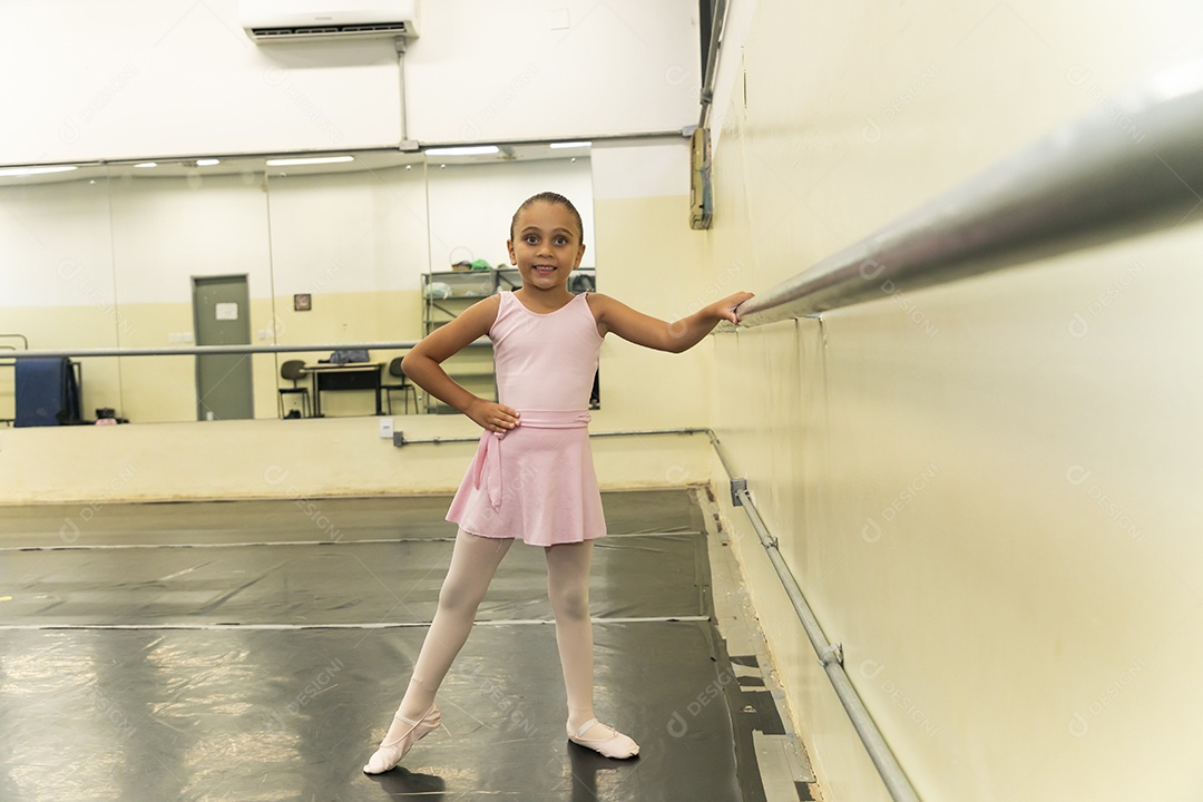 Linda menina sorridente praticando balé sobre escola de dança