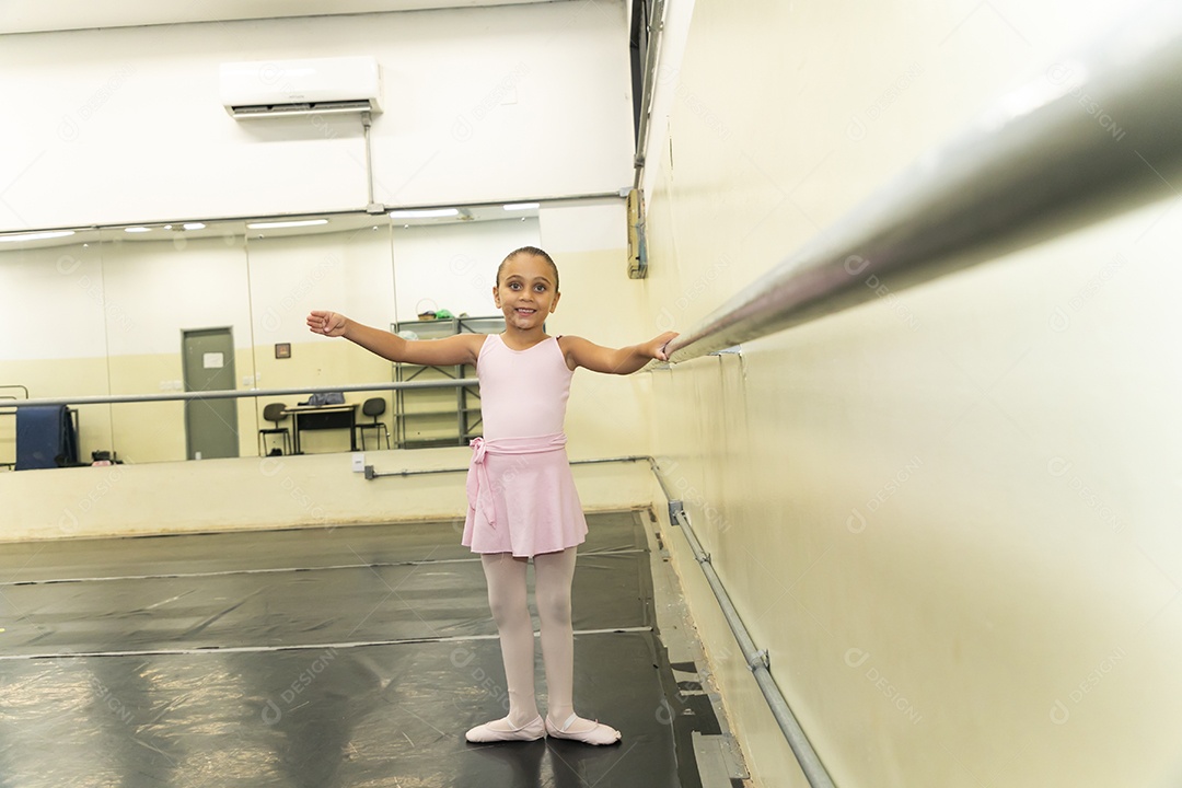 Linda menina sorridente praticando balé sobre escola de dança