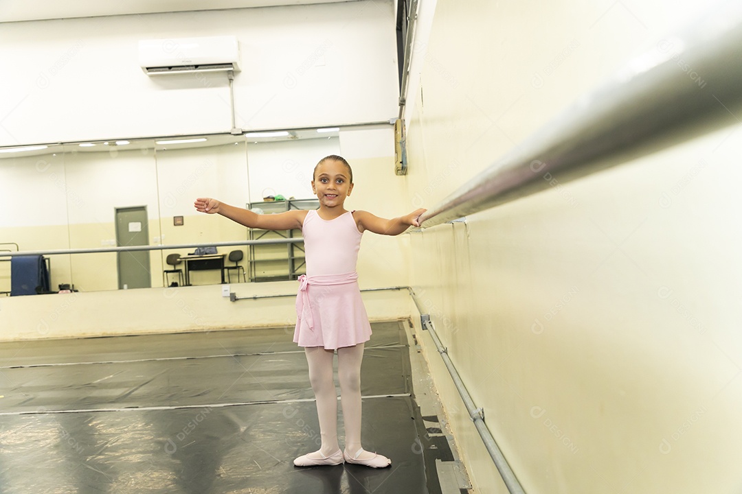 Linda menina sorridente praticando balé sobre escola de dança