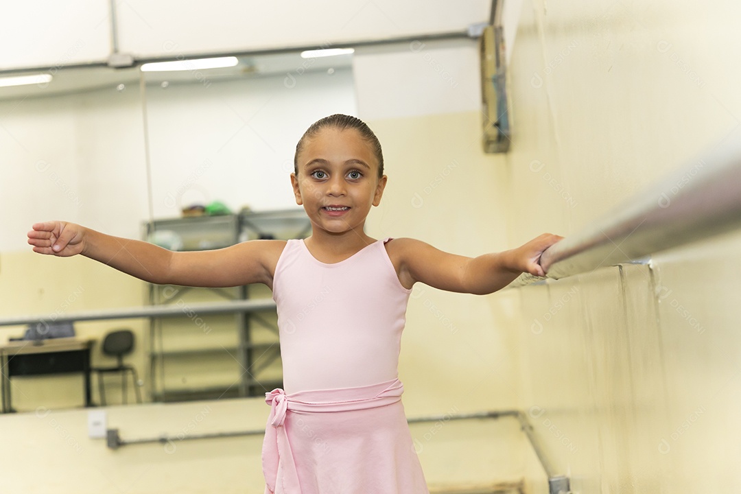 Linda menina sorridente praticando balé sobre escola de dança