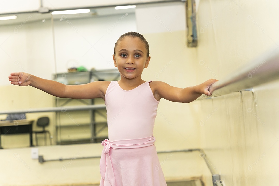 Linda menina sorridente praticando balé sobre escola de dança