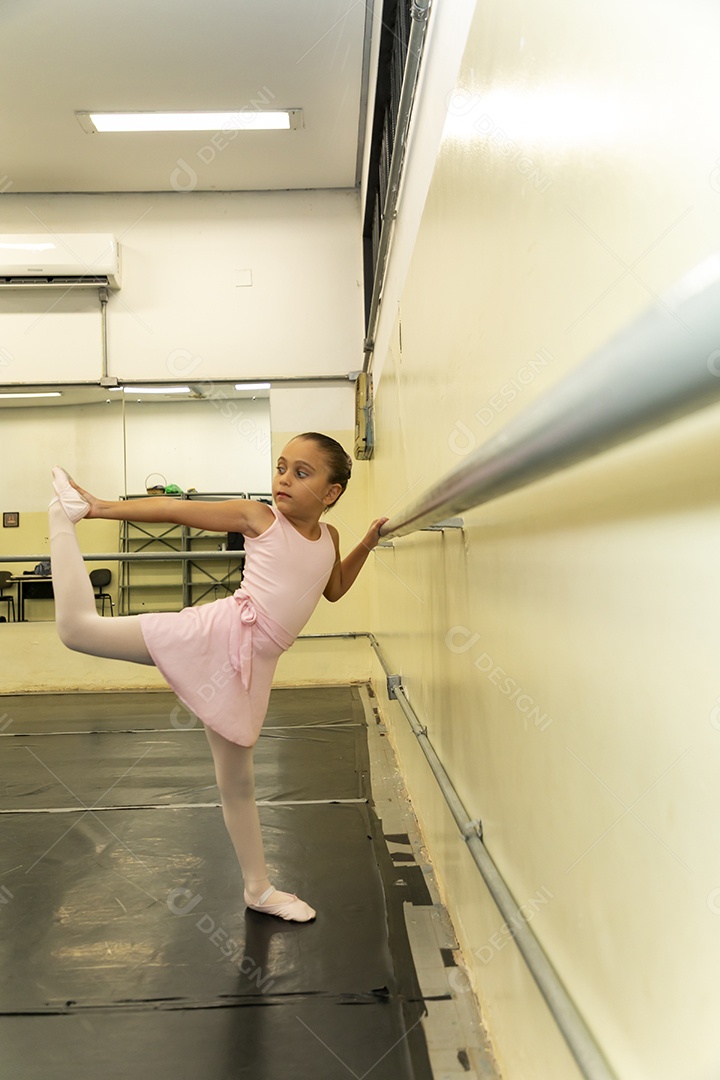 Linda menina sorridente praticando balé sobre escola de dança