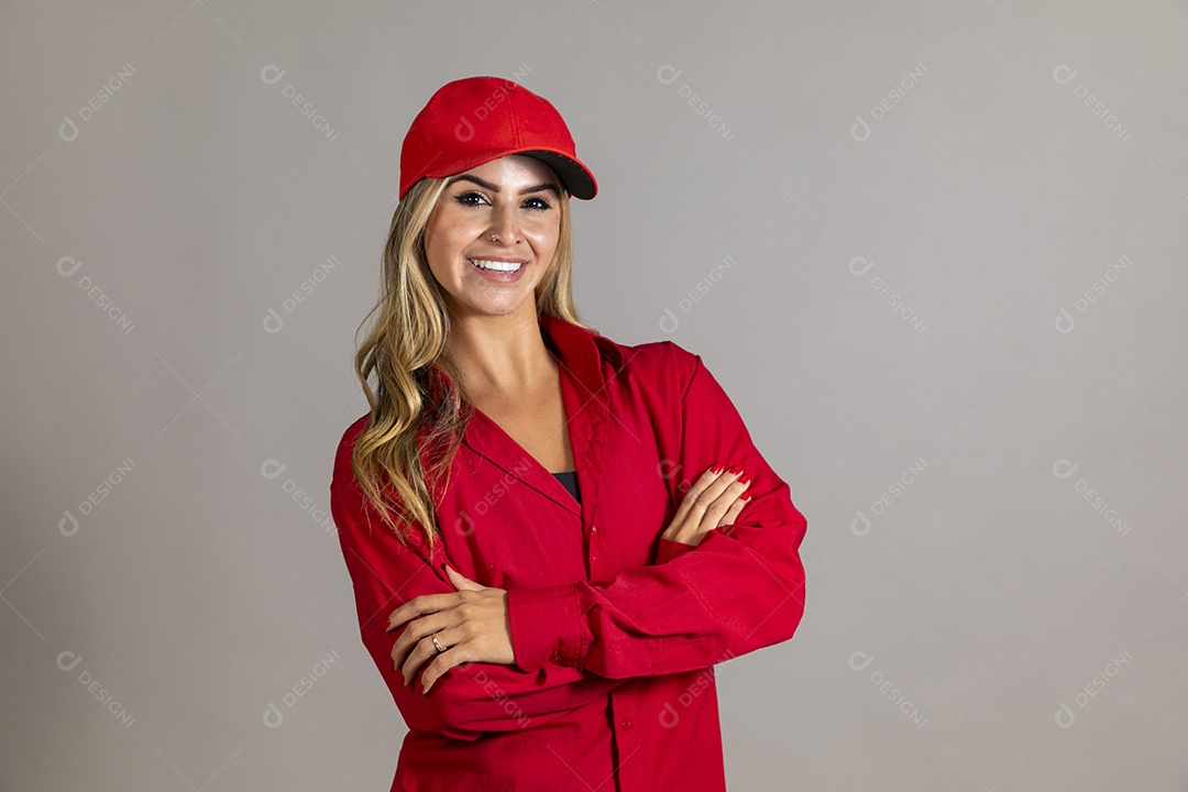 Bela mulher sorridente usando boné vermelho fazendo pose sobre fundo isolado
