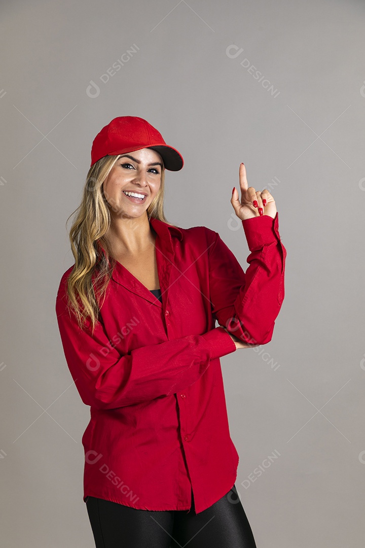 Bela mulher sorridente usando boné vermelho fazendo pose sobre fundo isolado