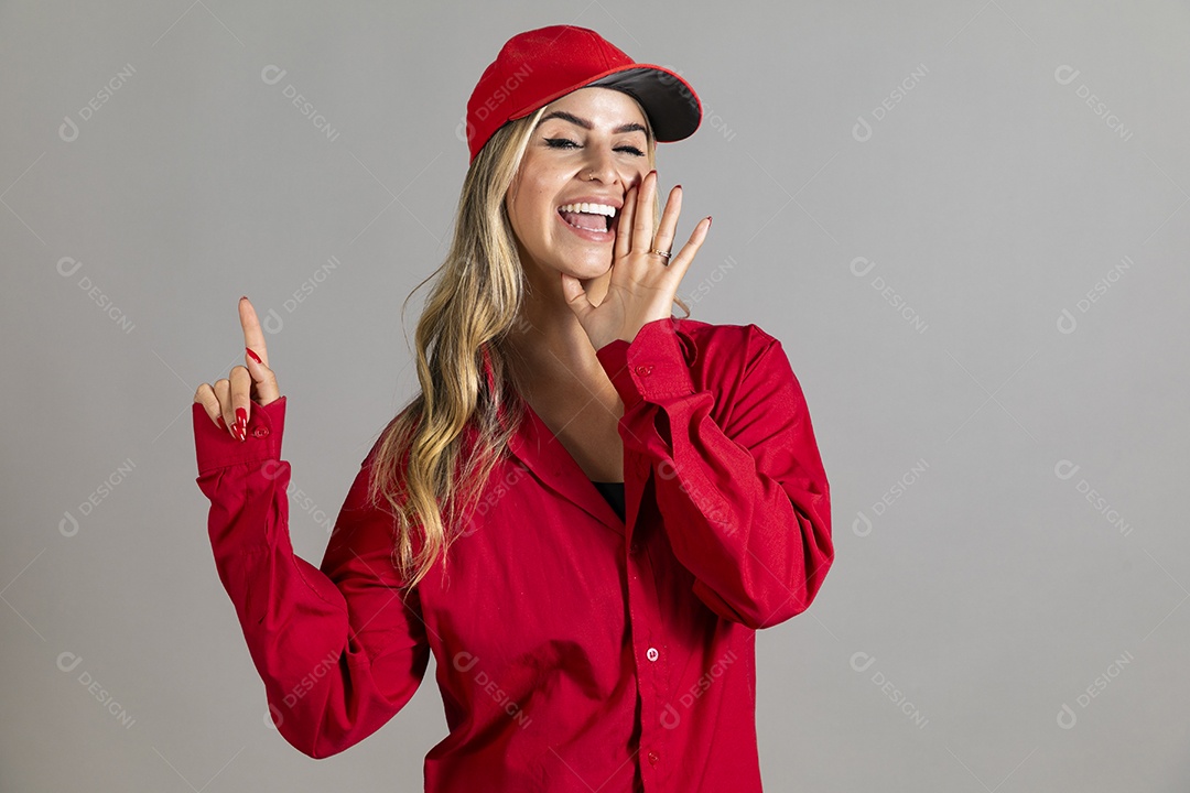 Bela mulher sorridente usando boné vermelho fazendo pose sobre fundo isolado