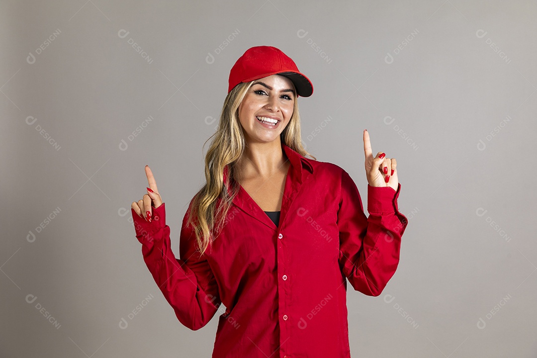 Bela mulher sorridente usando boné vermelho fazendo pose sobre fundo isolado