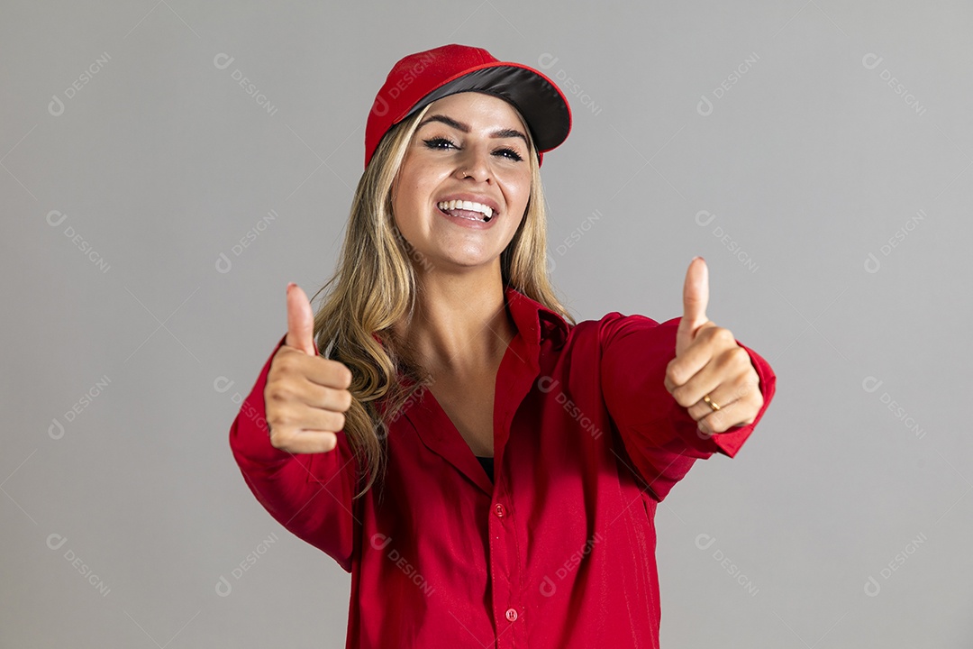 Bela mulher sorridente usando boné vermelho fazendo pose sobre fundo isolado