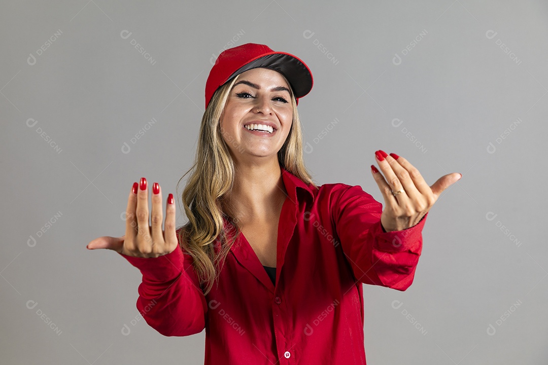 Bela mulher sorridente usando boné vermelho fazendo pose sobre fundo isolado
