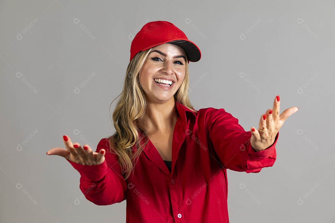 Bela mulher sorridente usando boné vermelho fazendo pose sobre fundo isolado