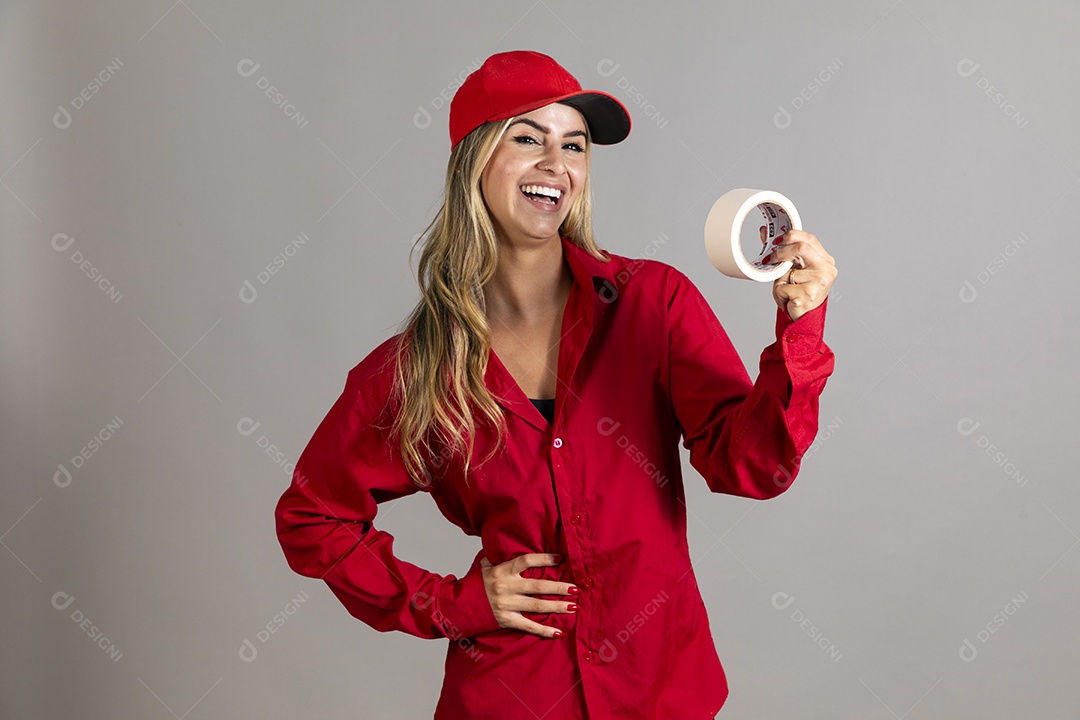 Bela mulher sorridente usando boné segurando fita isolante em branco sobre fundo isolado