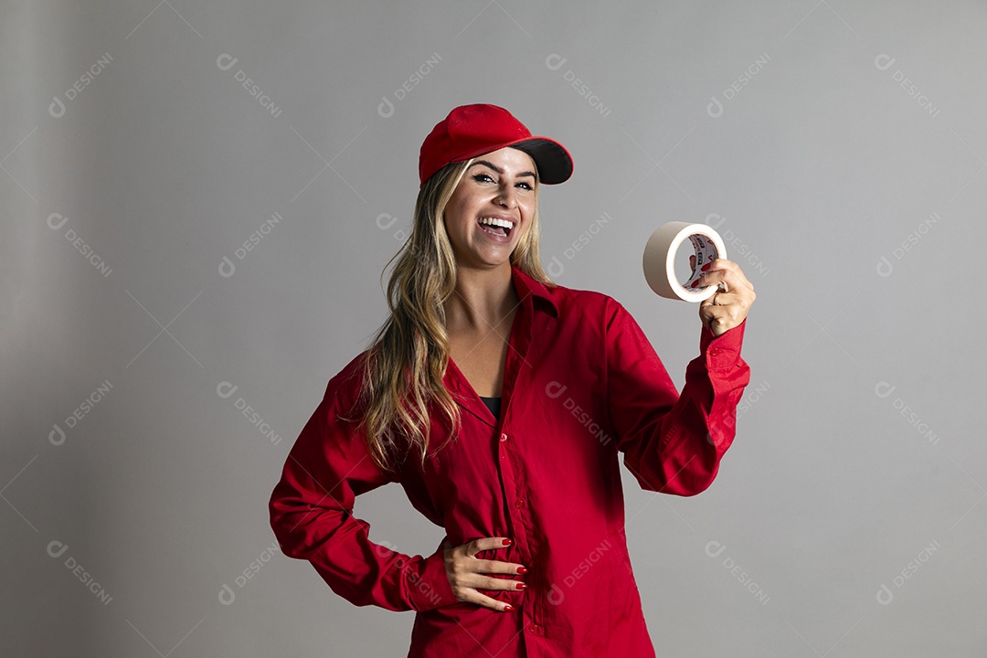 Bela mulher sorridente usando boné segurando fita isolante em branco sobre fundo isolado
