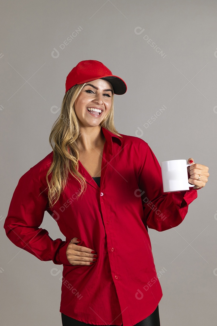 Bela mulher sorridente usando boné segurando caneca sobre fundo isolado