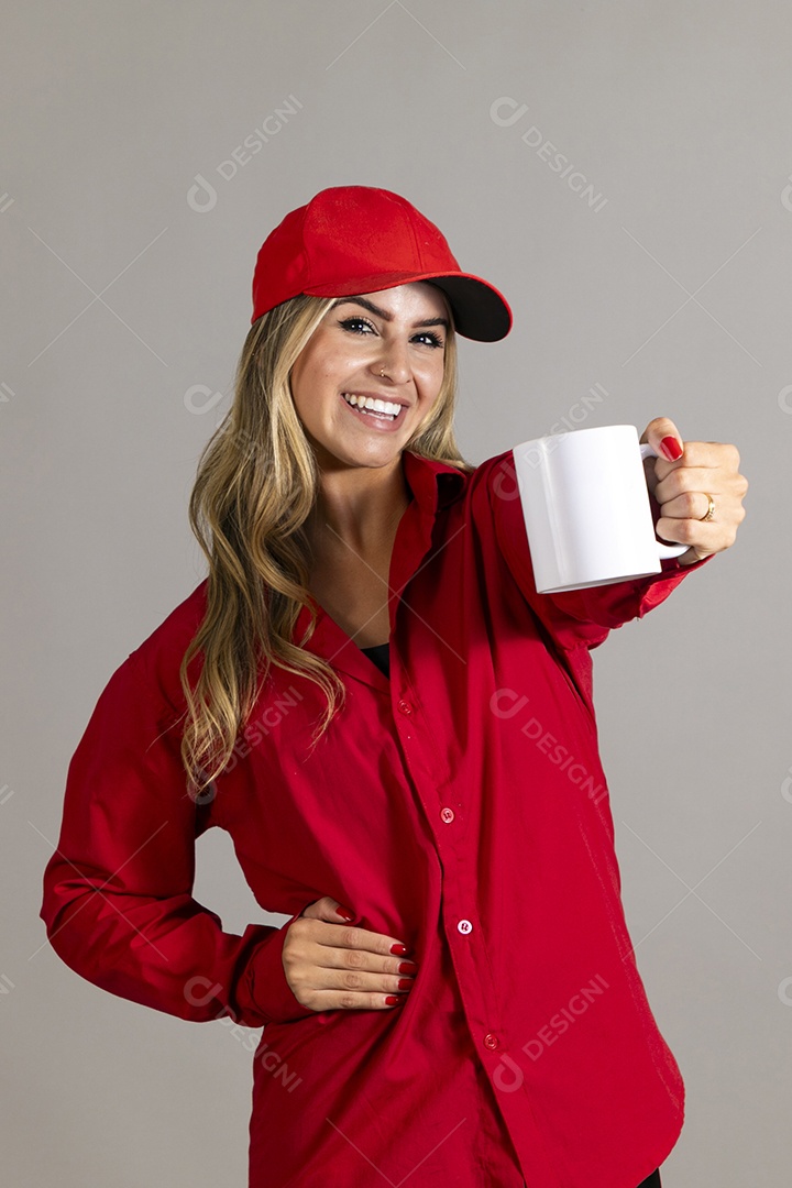 Bela mulher sorridente usando boné segurando caneca sobre fundo isolado