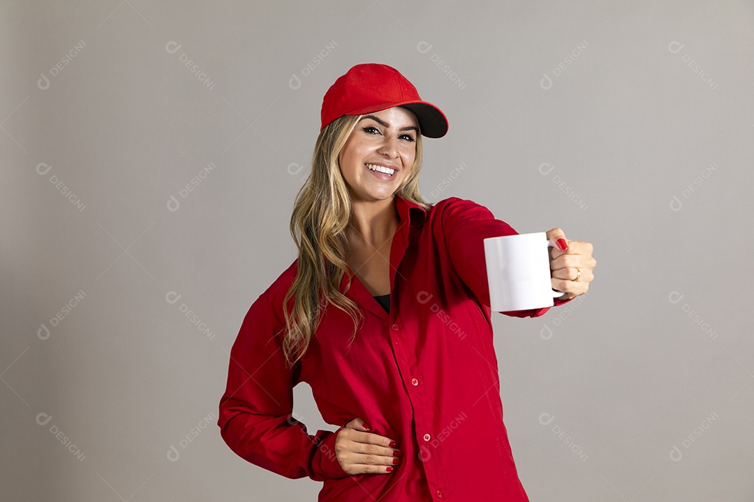 Bela mulher sorridente usando boné segurando caneca sobre fundo isolado