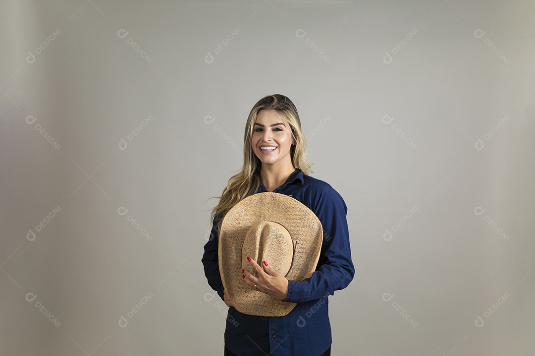 Linda mulher da pele clara de macacão segurando chápeu sobre fundo Isolado