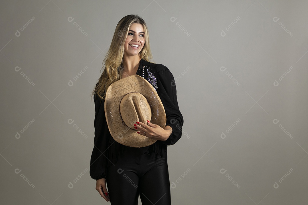 Linda mulher da pele clara de camisa longa segurando chápeu sobre fundo Isolado