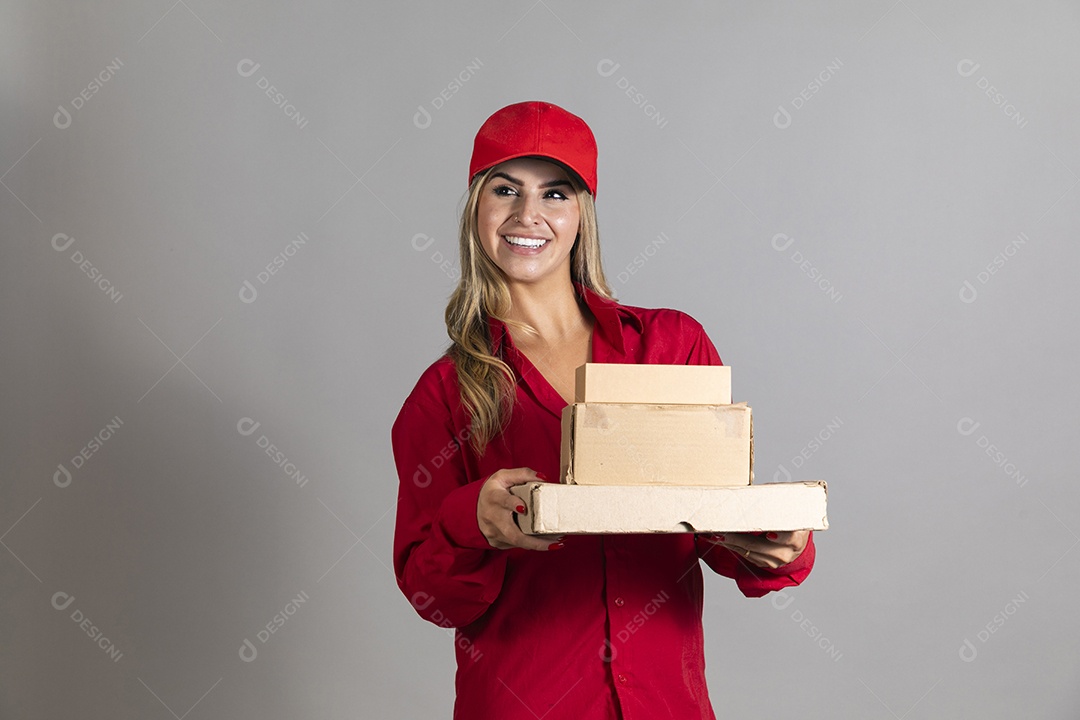 Bela mulher sorridente usando boné segurando pequenas caixas de papelão sobre fundo isolado
