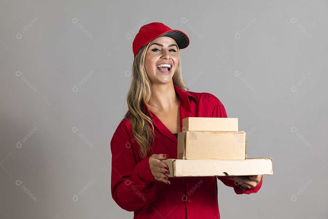 Bela mulher sorridente usando boné segurando pequenas caixas de papelão sobre fundo isolado