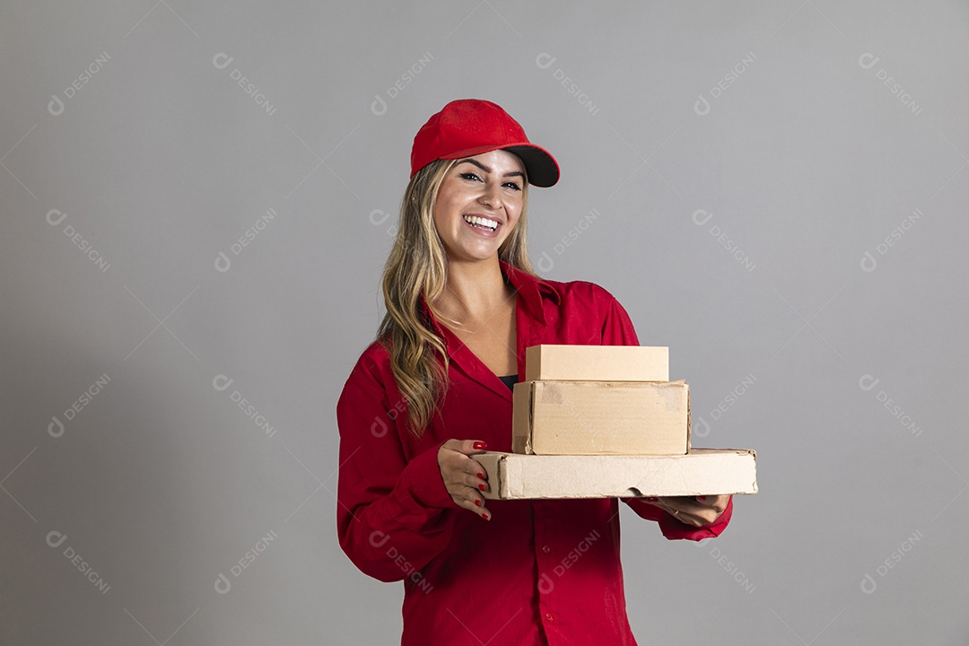 Bela mulher sorridente usando boné segurando pequenas caixas de papelão sobre fundo isolado