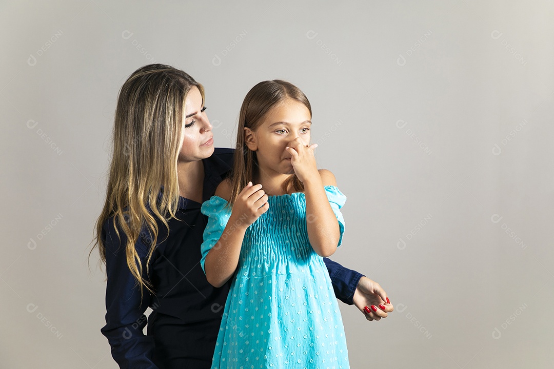 Mãe cuidando de sua filha com fortes dores de nariz sobre fundo isolado