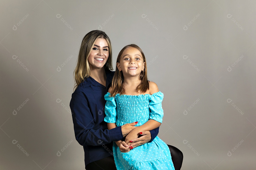 Bela filha sentada sobre colo de sua mãe sobre um fundo isolado