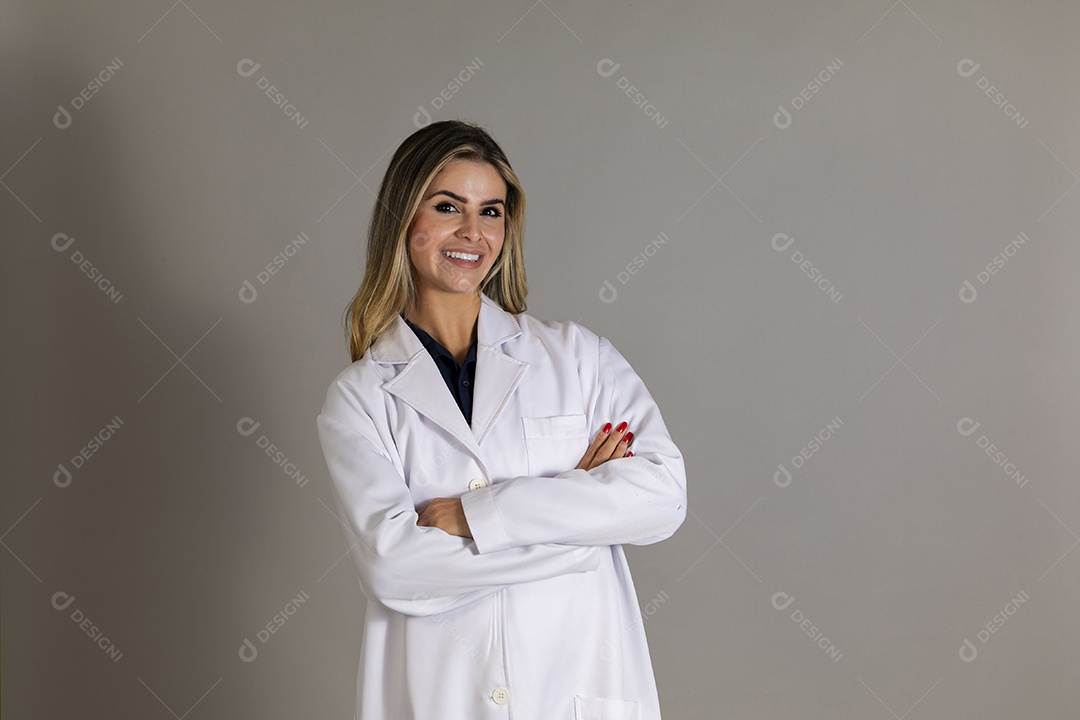 Linda enfermeira usando jaleco branco com braços cruzados sobre fundo isolado