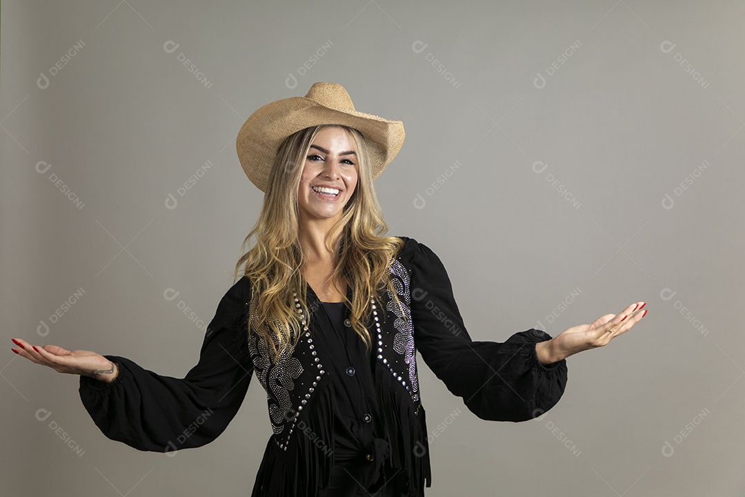 Linda mulher com look country com chápeu de palha sobre fundo isolado