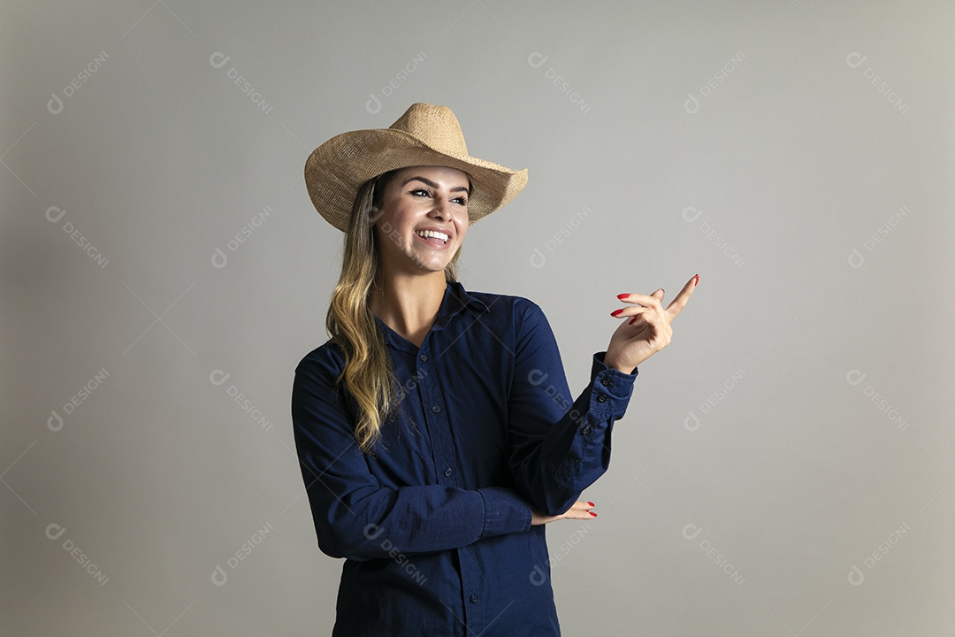 Linda mulher com look country com chápeu de palha sobre fundo isolado