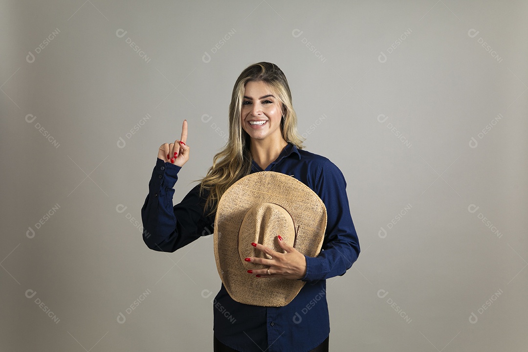Linda mulher com look country com chápeu de palha sobre fundo isolado
