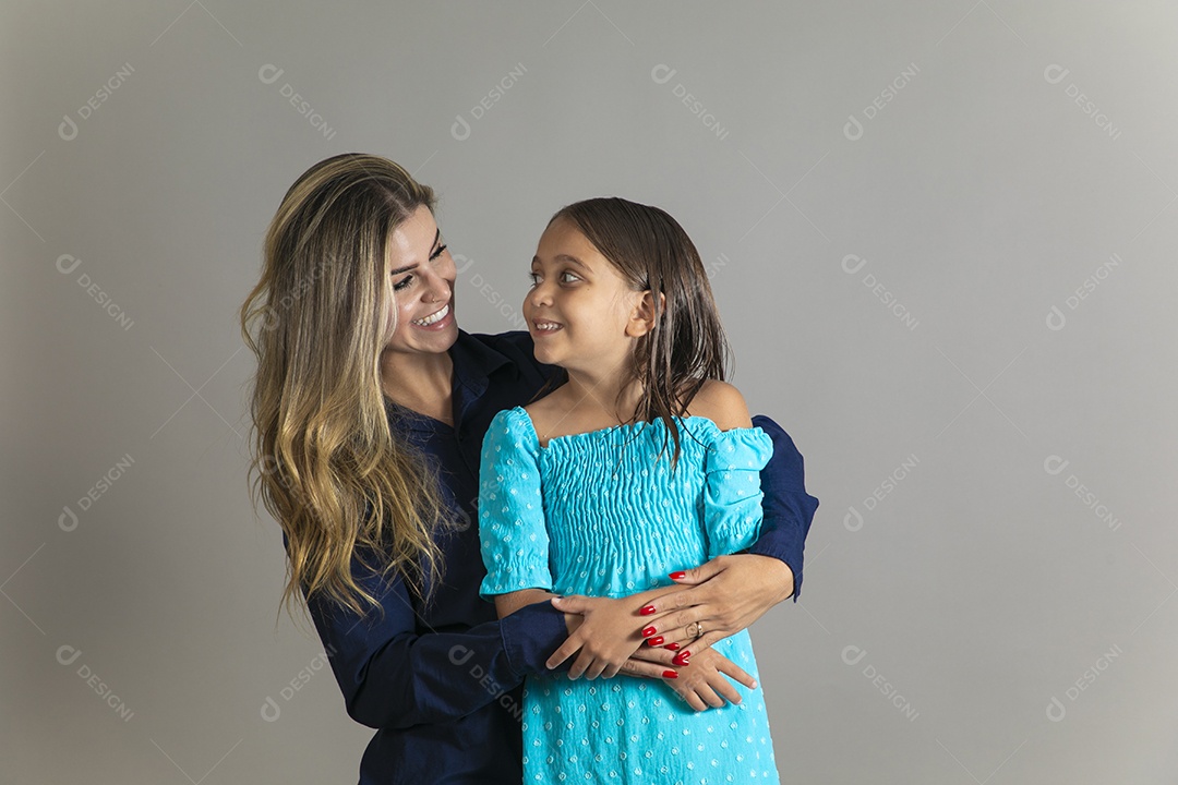 Belo retrato de mãe e filha sorridente fazendo pose sobre fundo isolado