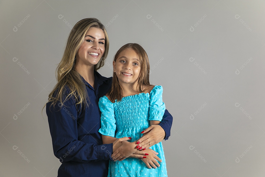 Belo retrato de mãe e filha sorridente fazendo pose sobre fundo isolado