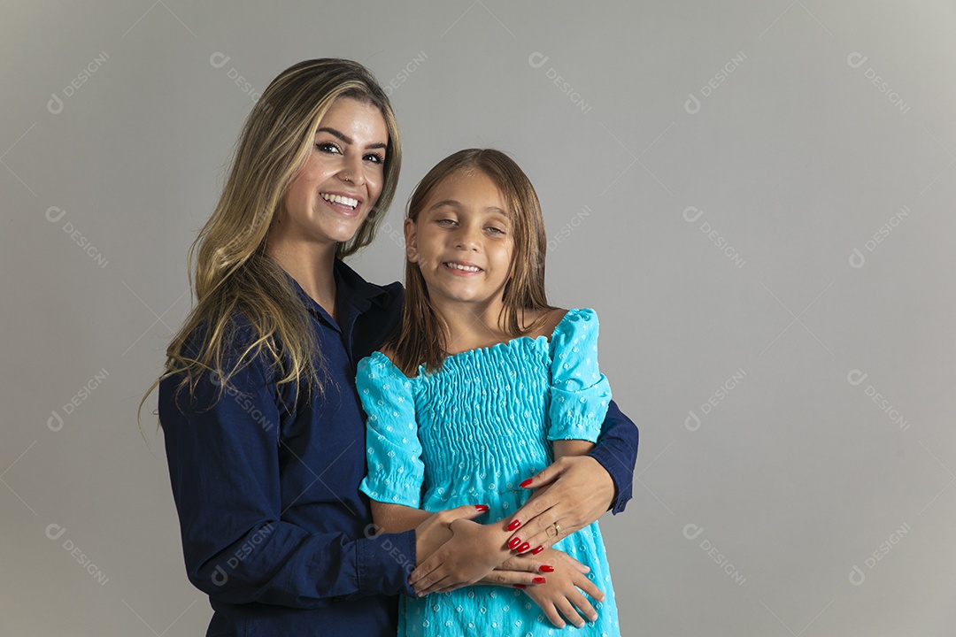 Belo retrato de mãe e filha sorridente fazendo pose sobre fundo isolado