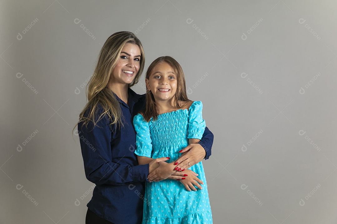 Belo retrato de mãe e filha sorridente fazendo pose sobre fundo isolado