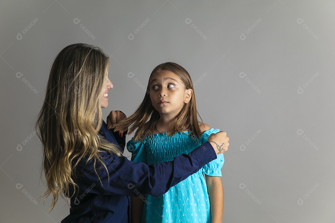 Belo retrato de mãe e filha sorridente fazendo pose sobre fundo isolado