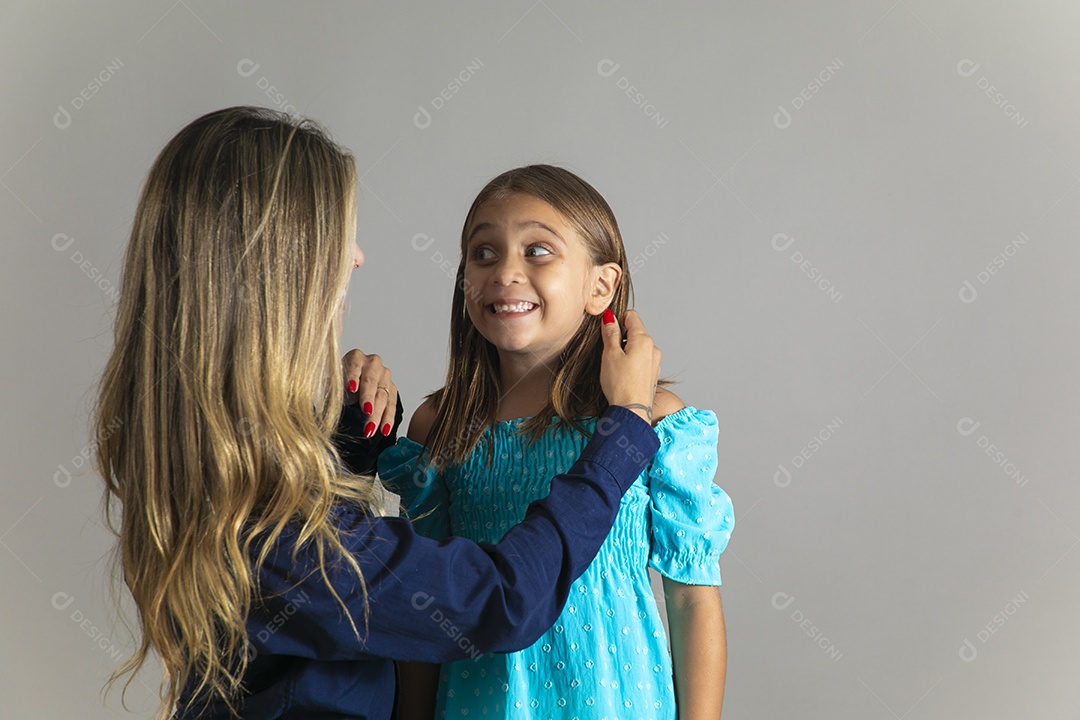Belo retrato de mãe e filha sorridente fazendo pose sobre fundo isolado