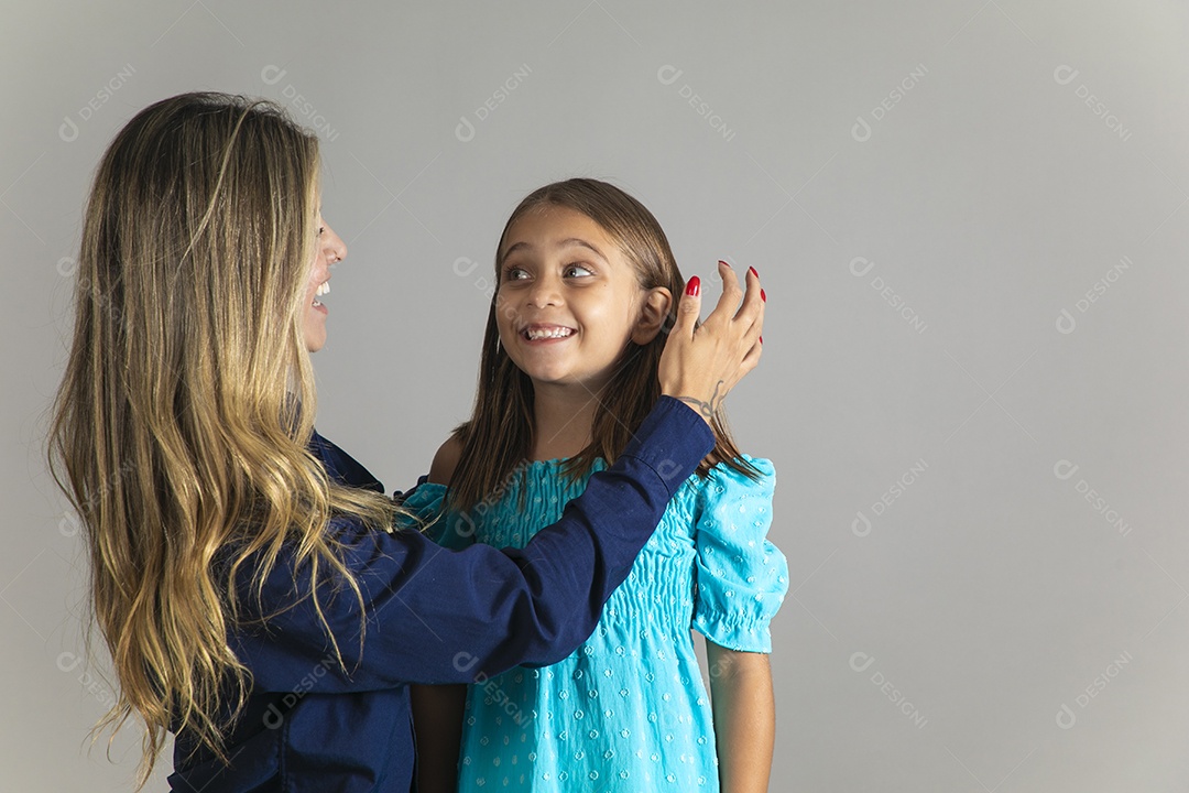 Belo retrato de mãe e filha sorridente fazendo pose sobre fundo isolado