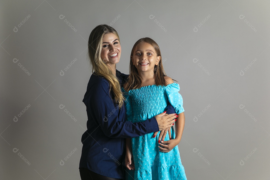 Belo retrato de mãe e filha sorridente fazendo pose sobre fundo isolado