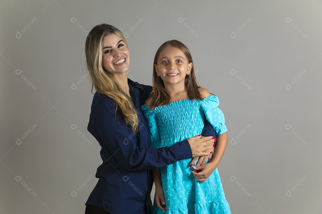 Belo retrato de mãe e filha sorridente fazendo pose sobre fundo isolado