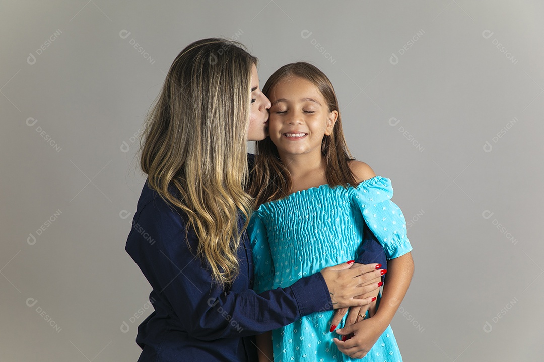 Belo retrato de mãe e filha sorridente fazendo pose sobre fundo isolado