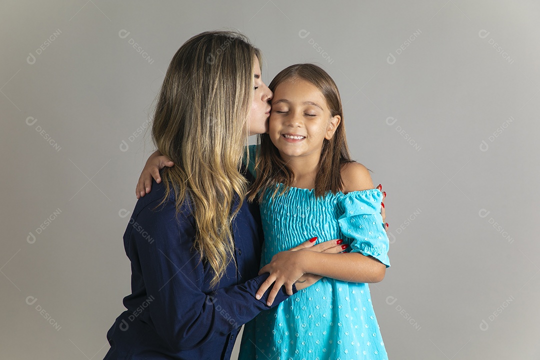 Belo retrato de mãe e filha sorridente fazendo pose sobre fundo isolado