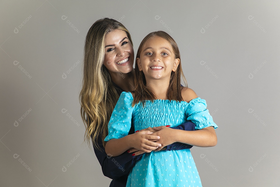 Belo retrato de mãe e filha sorridente se abraçando sobre fundo isolado