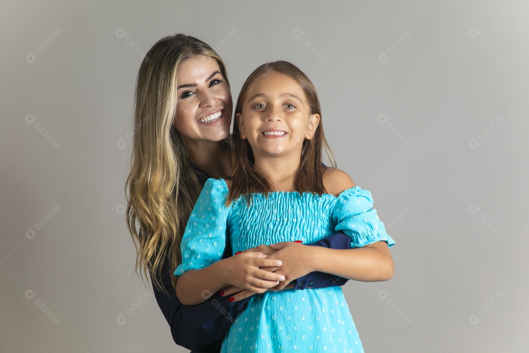 Belo retrato de mãe e filha sorridente se abraçando sobre fundo isolado