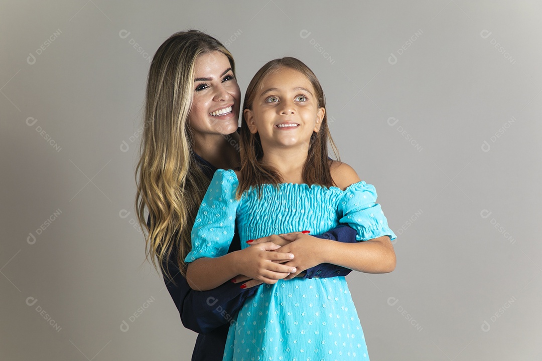 Belo retrato de mãe e filha sorridente se abraçando sobre fundo isolado