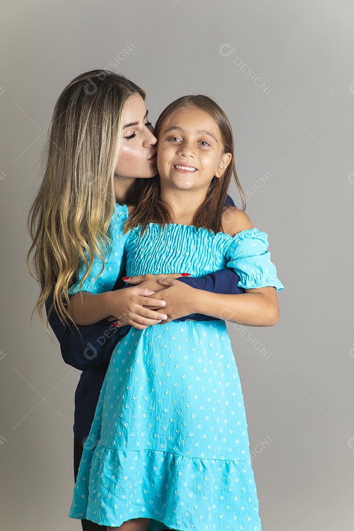Belo retrato de mãe e filha sorridente se abraçando sobre fundo isolado