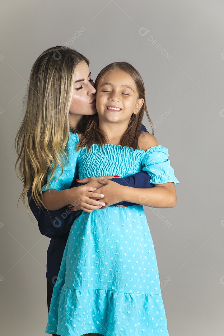 Belo retrato de mãe e filha sorridente se abraçando sobre fundo isolado