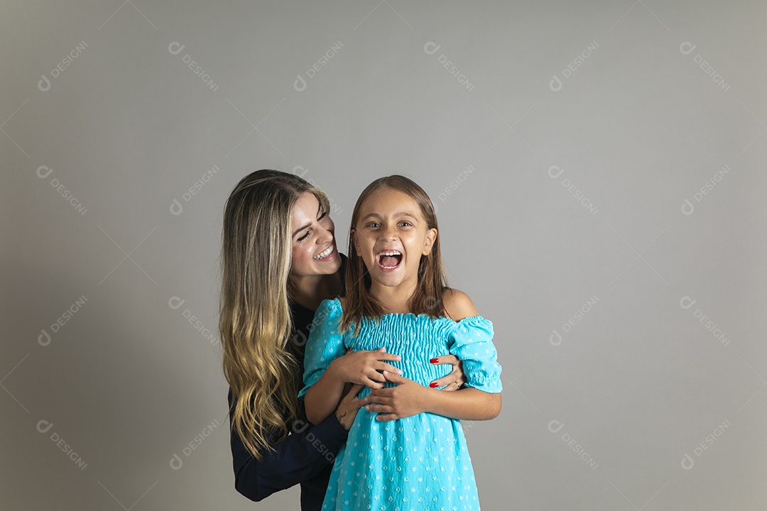 Belo retrato de mãe e filha sorridente se abraçando sobre fundo isolado