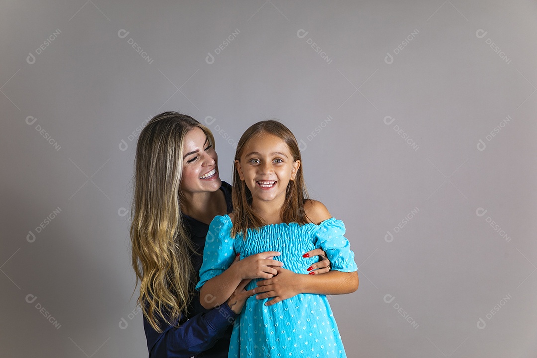 Belo retrato de mãe e filha sorridente se abraçando sobre fundo isolado