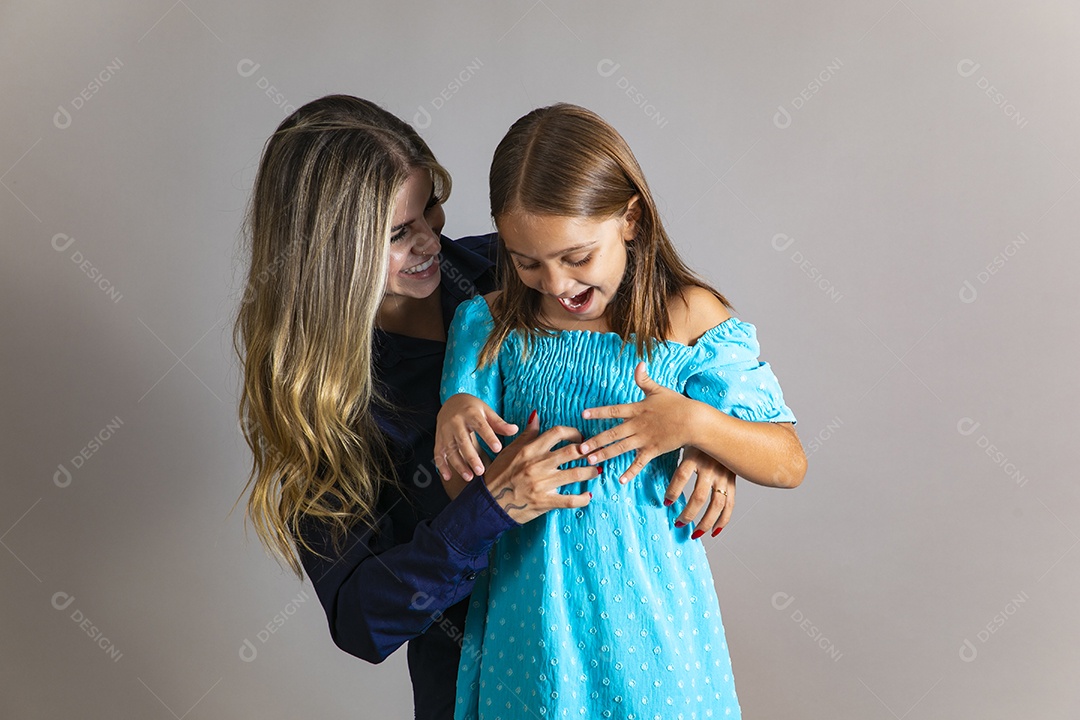 Belo retrato de mãe e filha sorridente se abraçando sobre fundo isolado