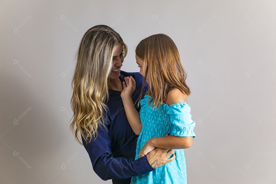Belo retrato de mãe e filha sorridente se abraçando sobre fundo isolado