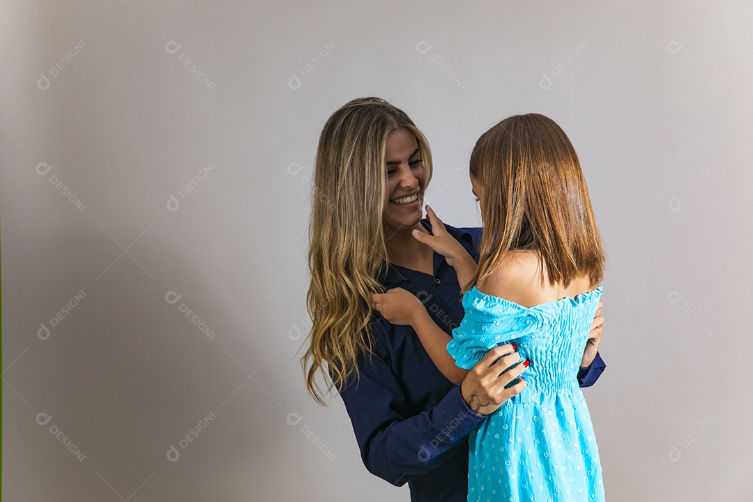 Belo retrato de mãe e filha sorridente se abraçando sobre fundo isolado